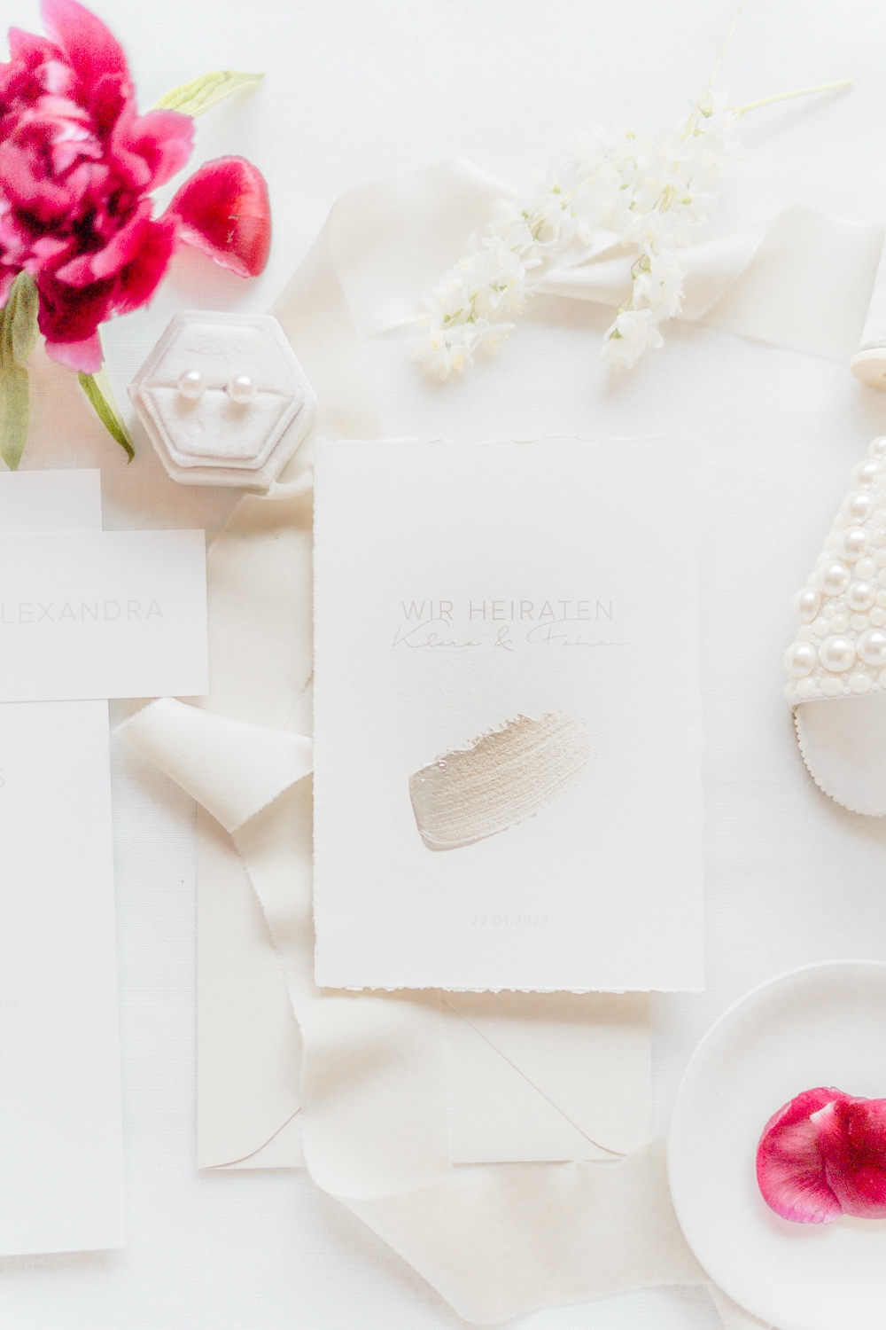 Hochzeitsfotograf Wien: Elegantes Flatlay mit Brautschuhen, Papeterie und Blüten.