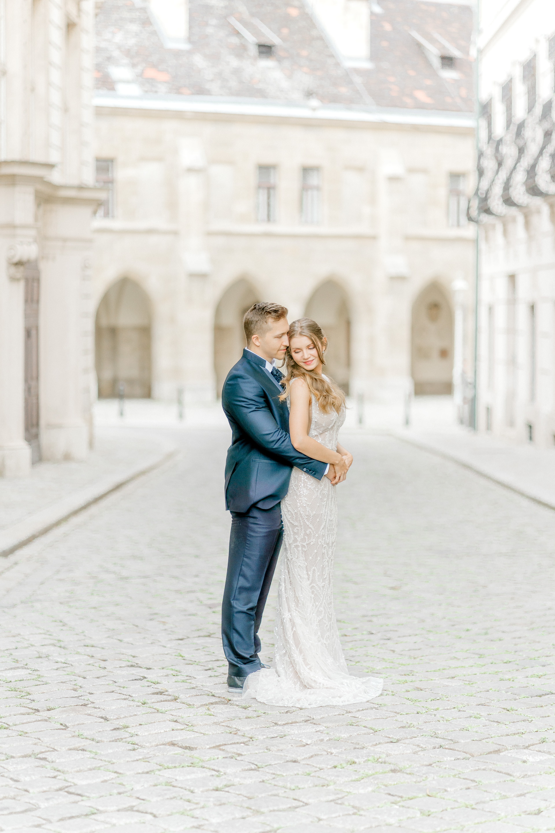 Hochzeitsfotograf Wien: Elegantes Brautpaar in inniger Umarmung in einer Gasse der Innenstadt Wien.